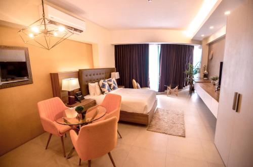 een hotelkamer met een bed en een tafel en stoelen bij AEON SUITES STAYCATION managed by ARIA HOTEL in Davao City