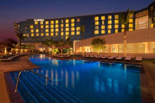 ein Hotel mit einem Pool vor einem Gebäude in der Unterkunft Le Meridien Cairo Airport in Kairo