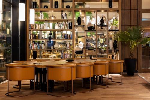 un restaurante con un bar con taburetes y libros en Tunis Marriott Hotel, en Túnez