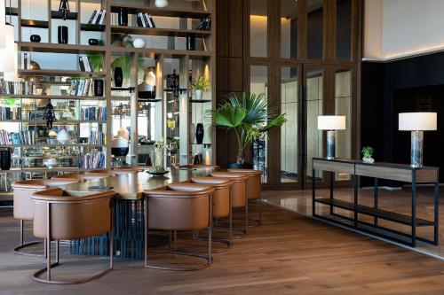 un bar con taburetes de cuero en una biblioteca en Tunis Marriott Hotel, en Túnez