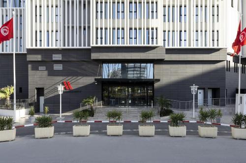 um edifício com vasos de plantas à sua frente em Tunis Marriott Hotel em Tunes