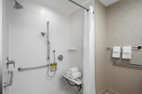 La salle de bains est pourvue d'une douche, de toilettes et de serviettes. dans l'établissement Holiday Inn Express & Suites Woodside LaGuardia Airport, à Queens