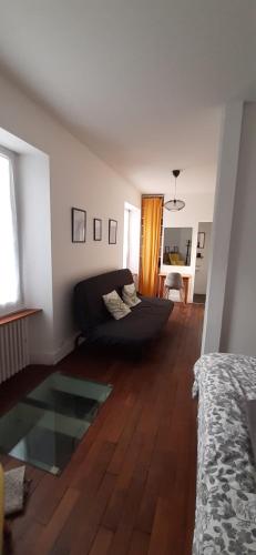 a living room with a couch and a wooden floor at Ker Karantez in Rennes