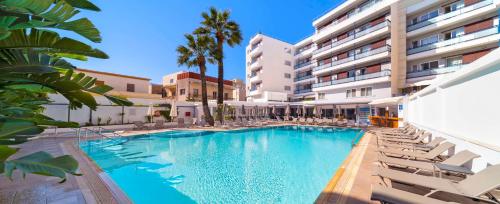 einen Pool mit Stühlen und ein Gebäude in der Unterkunft Best Western Plus Hotel Plaza in Rhodos (Stadt)