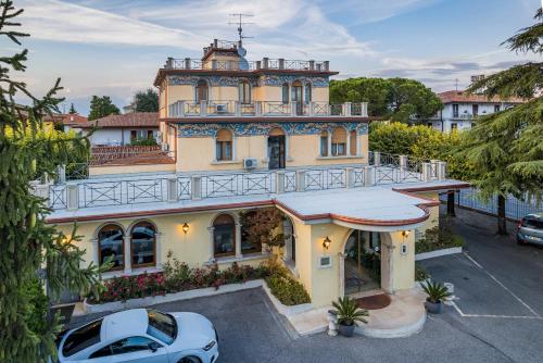 um carro branco estacionado em frente a uma casa em Hotel Gardenia Sirmione em Sirmione