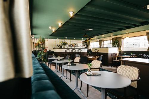 un restaurant avec des tables et des chaises ainsi qu'un bar dans l'établissement Botel Maastricht, à Maastricht