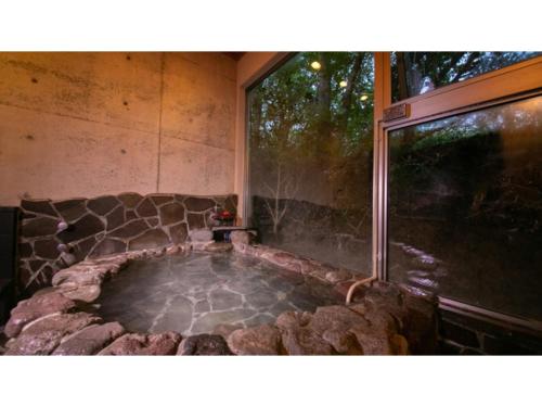 uma banheira de hidromassagem num quarto com uma grande janela em Innterhill Tsubasa Yufuin - Vacation STAY 94230v em Yufu