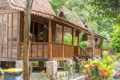 una casa in legno nel bosco con un albero di Jukung Cottage a Nusa Penida