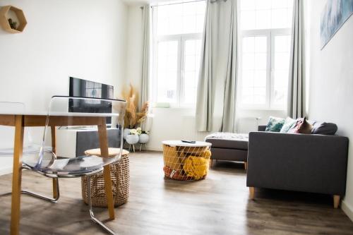 een woonkamer met een tafel en een bank bij Hotel Industrie in Leuven