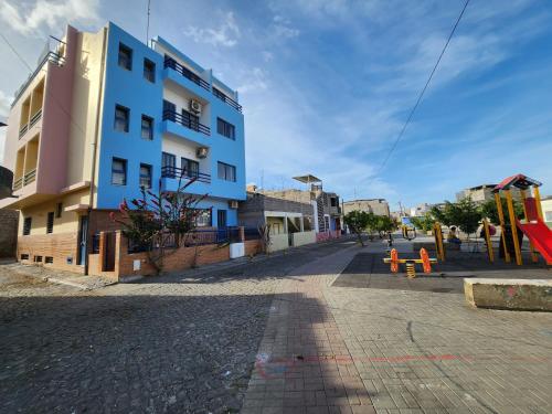 um edifício numa rua com um parque infantil em frente em Txada Hostel em Praia