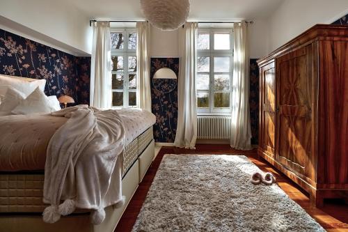 um quarto com uma cama, 2 janelas e um tapete em Boutique Suites Heidelberg Alte Zigarrenmanufaktur em Heidelberg