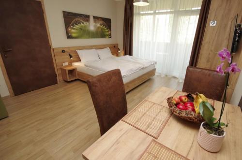 een slaapkamer met een bed en een tafel met een fruitschaal bij Almásy Apartmanház Gyula in Gyula