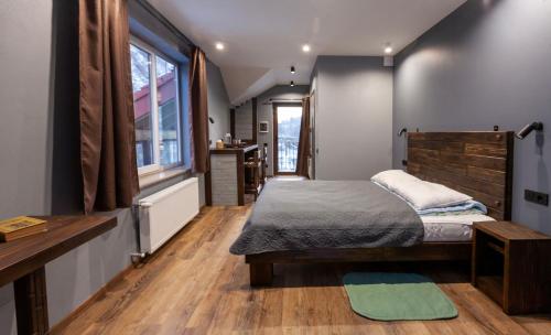 a bedroom with a bed and a wooden floor at Гостьовий дім Білий пацюк in Kamianets-Podilskyi