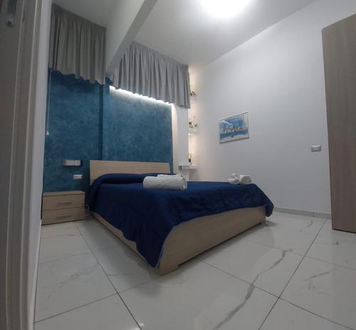 een slaapkamer met een bed met blauwe lakens en een raam bij Stabia Dream Rooms in Castellammare di Stabia