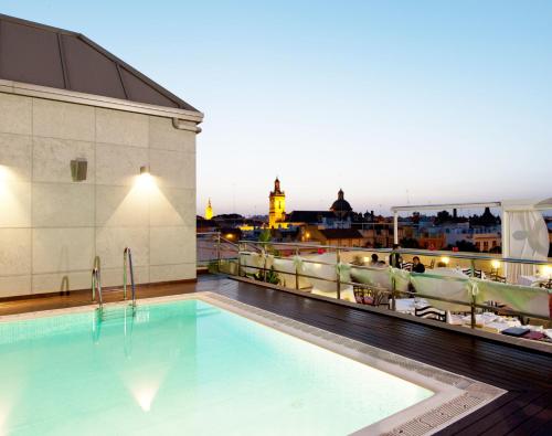 une piscine sur le toit d'un bâtiment dans l'établissement Hotel Sevilla Center, à Séville