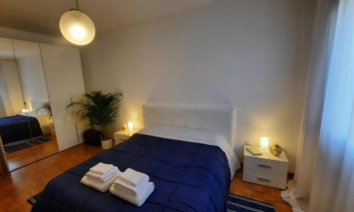 een slaapkamer met een blauw bed en handdoeken bij Verdisuite - Trento centro - Parcheggio privato gratuito in Trento