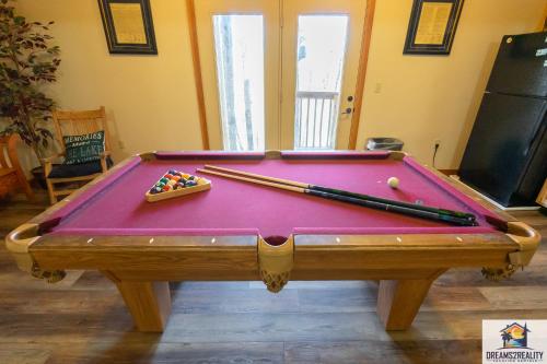 - un billard avec des billes et des baguettes dans l'établissement Forest Heights Lodge - 6BR - Pool Table - Near Silver Dollar City - FREE TICKETS INCLUDED, à Branson