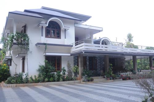 Casa bianca con balcone e cortile di Misty Retreat (Pragati House) a Madikeri