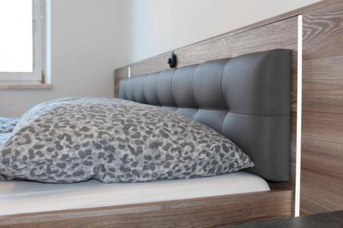 a bed with a black and gray pillow on it at Zum Breyer BNB City Apartment in Baden