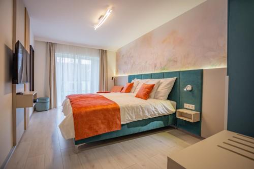 een slaapkamer met een groot bed en een oranje deken bij Viktória Apartman in Gyula