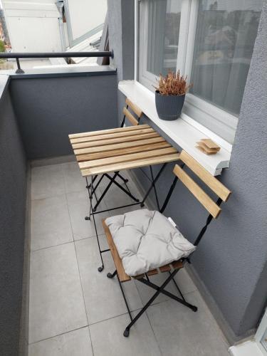 een kleine tafel en een stoel op een balkon bij Green and grey in Novi Sad