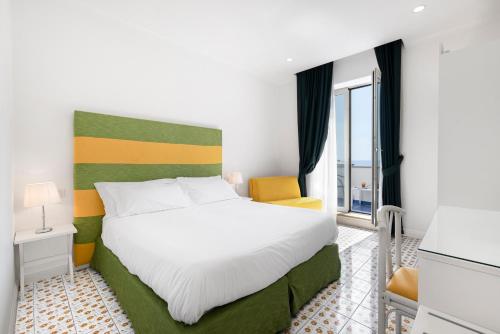 um quarto de hotel com uma cama e uma janela em Hotel Bougainville em Positano