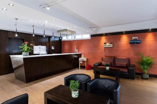 une salle d'attente avec un comptoir, des chaises et des tables dans l'établissement Petit Palace Arturo Soria Alcalá, à Madrid