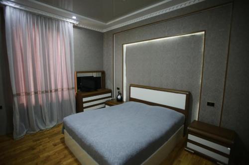 una piccola camera con letto e televisore di Guest House Nikola a Zugdidi