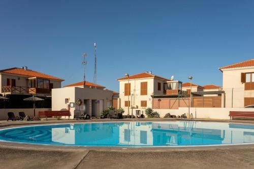 una grande piscina in un cortile con case di Villa Calderón Hondo. Top design , views and pool Lajares-Corralejo a Corralejo