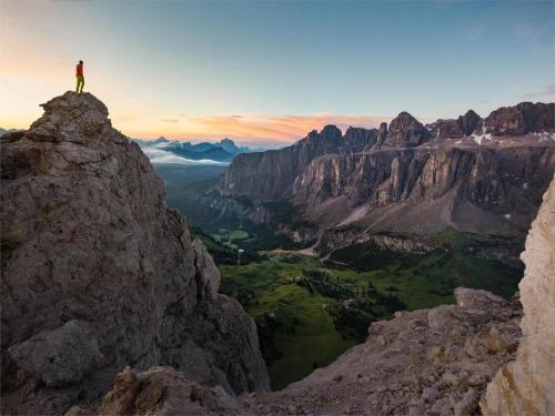 osoba stojąca na szczycie góry w obiekcie Rifugio Frara w mieście Selva di Val Gardena