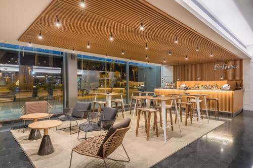 un restaurant avec des tables et des chaises dans un bâtiment dans l'établissement Occidental Atenea Mar - Adults Only, à Barcelone