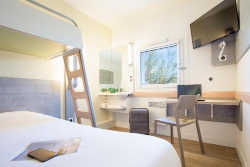 - une chambre avec un lit et un bureau avec un ordinateur dans l'établissement Ibis Budget Fréjus Capitou, à Fréjus