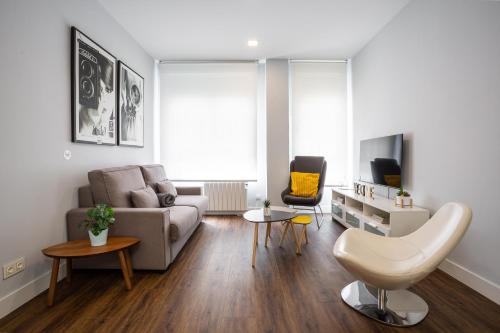 uma sala de estar com um sofá e uma mesa em Apt nuevo! 2 hab, baño doble, garaje, Metro a 200m em Madrid