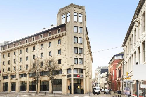 a tall building on a city street with buildings at ibis Gent Centrum St. Baafs Kathedraal in Ghent