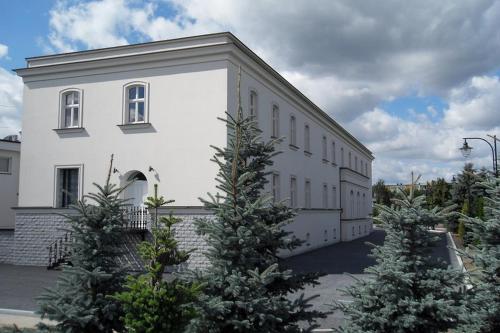 a large white building with christmas trees in front of it at Adler in Swarzędz