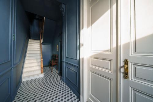 a hallway with blue walls and a white door at à la pointe de l'ile in Namur