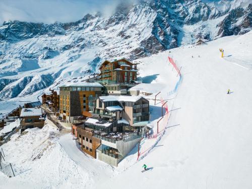 um hotel numa pista de esqui na neve em Bergman Mountain Hotel em Breuil-Cervinia