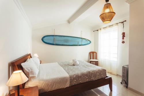 - une chambre avec un lit et une planche de surf bleue sur le mur dans l'établissement Best Houses 45 - Beautiful ocean and city view, à Peniche