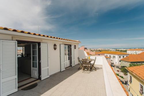 - un balcon avec une table et des chaises dans un bâtiment dans l'établissement Best Houses 45 - Beautiful ocean and city view, à Peniche