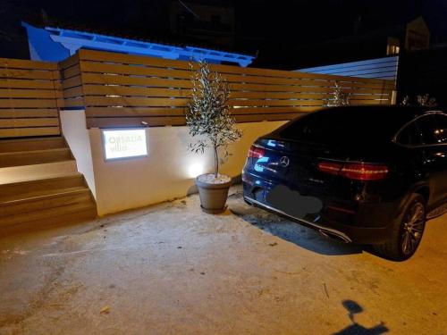 a car parked next to a fence with a potted plant at Orsalia villa wellness in Poros