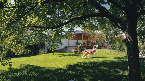 Una donna seduta su una sedia in un giardino di Hotel Zum Schiff a Friburgo in Brisgovia