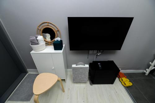 a room with a flat screen tv and a chair at Aha Stay in Gyeongju