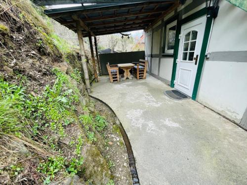 um alpendre de uma casa com uma mesa e cadeiras em Kleine Wohnung am Bach em Neuwerk