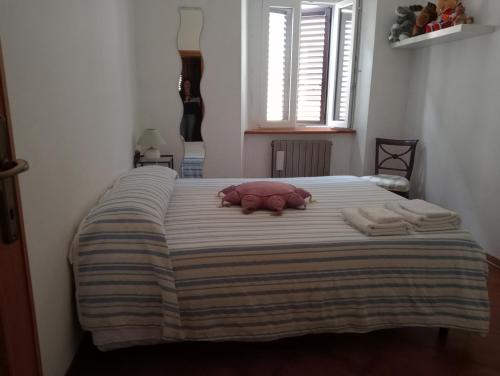 ein Bett mit einem rosa ausgestopften Tier, das darauf liegt in der Unterkunft Casa Azzurra in Orbetello