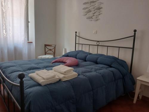 ein blaues Bett mit Handtüchern darüber in der Unterkunft Casa Azzurra in Orbetello