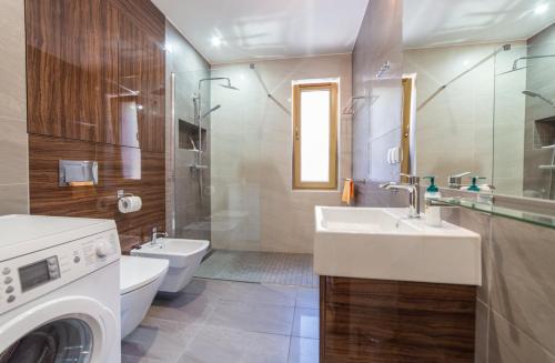 a bathroom with a sink and a washing machine at Villa Arkadia in Łukęcin