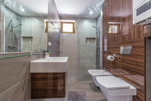 a bathroom with a sink and a toilet and a mirror at Villa Arkadia in Łukęcin