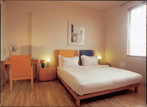 A bed or beds in a room at The Gordon House Hotel, Colaba