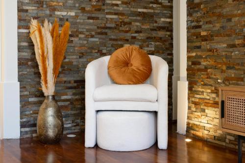 a white chair with a pillow on it next to a vase at Charming Apt in Historic House in Coimbra