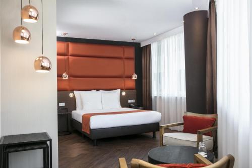 um quarto de hotel com uma cama e uma cadeira em Holiday Inn Amsterdam - Arena Towers, an IHG Hotel em Amesterdão